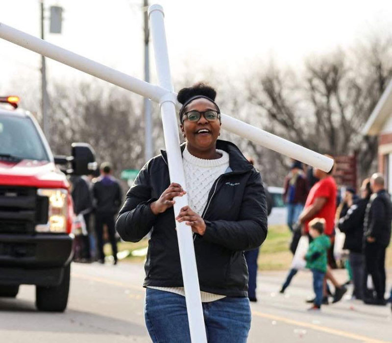 Image of Taneisha Butts carrying a cross in the street